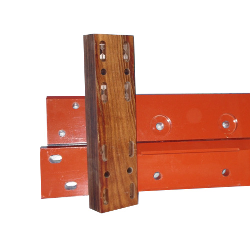 Three orange metal beams with circular holes are stacked horizontally. A vertical wooden block with multiple elongated slots and holes is placed in front of the beams.