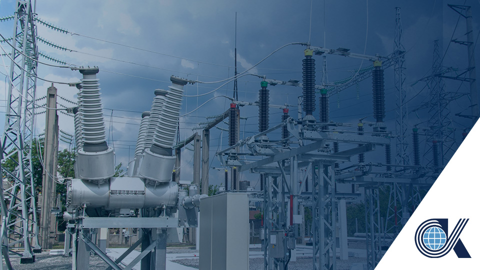 Electrical substation with transformers, circuit breakers, and power lines under a cloudy sky; CK logo in the bottom right corner.