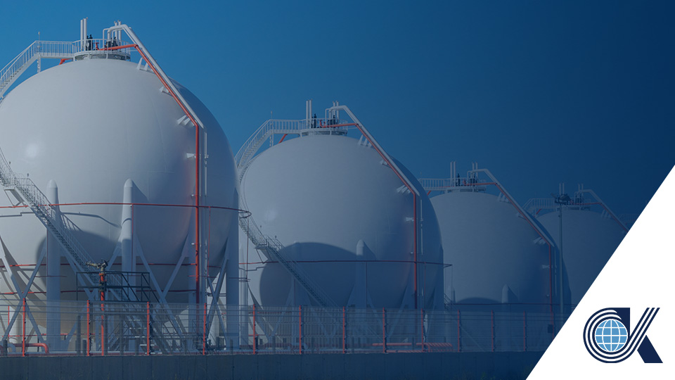 Large spherical storage tanks for gas or chemicals are lined up at an industrial facility, with railings and ladders. A company logo appears in the bottom right corner.